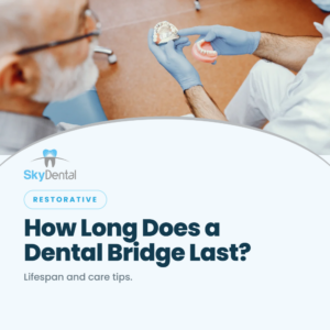 Dentist holding upper and lower denture models to show a patient, SkyDental Restorative blog cover: How Long Does a Dental Bridge Last? – lifespan and care tips.