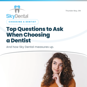Woman with curly hair resting her hand on her chin in a thoughtful pose, SkyDental Choosing a Dentist blog cover: Top Questions to Ask When Choosing a Dentist – and how Sky Dental measures up.