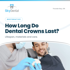 Dentist showing smiling male patient a dental crown model - how long do dental crowns last, lifespan materials and care, Sky Dental Thunder Bay