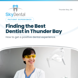 Smiling female dentist in yellow safety glasses standing beside dental exam light, SkyDental Patient Experience blog cover: Finding the Best Dentist in Thunder Bay – how to get a positive dental experience.