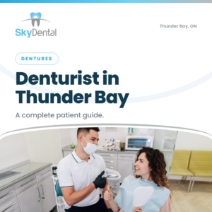 Denturist giving thumbs up to smiling patient holding a hand mirror - complete patient guide to a denturist in Thunder Bay, Sky Dental